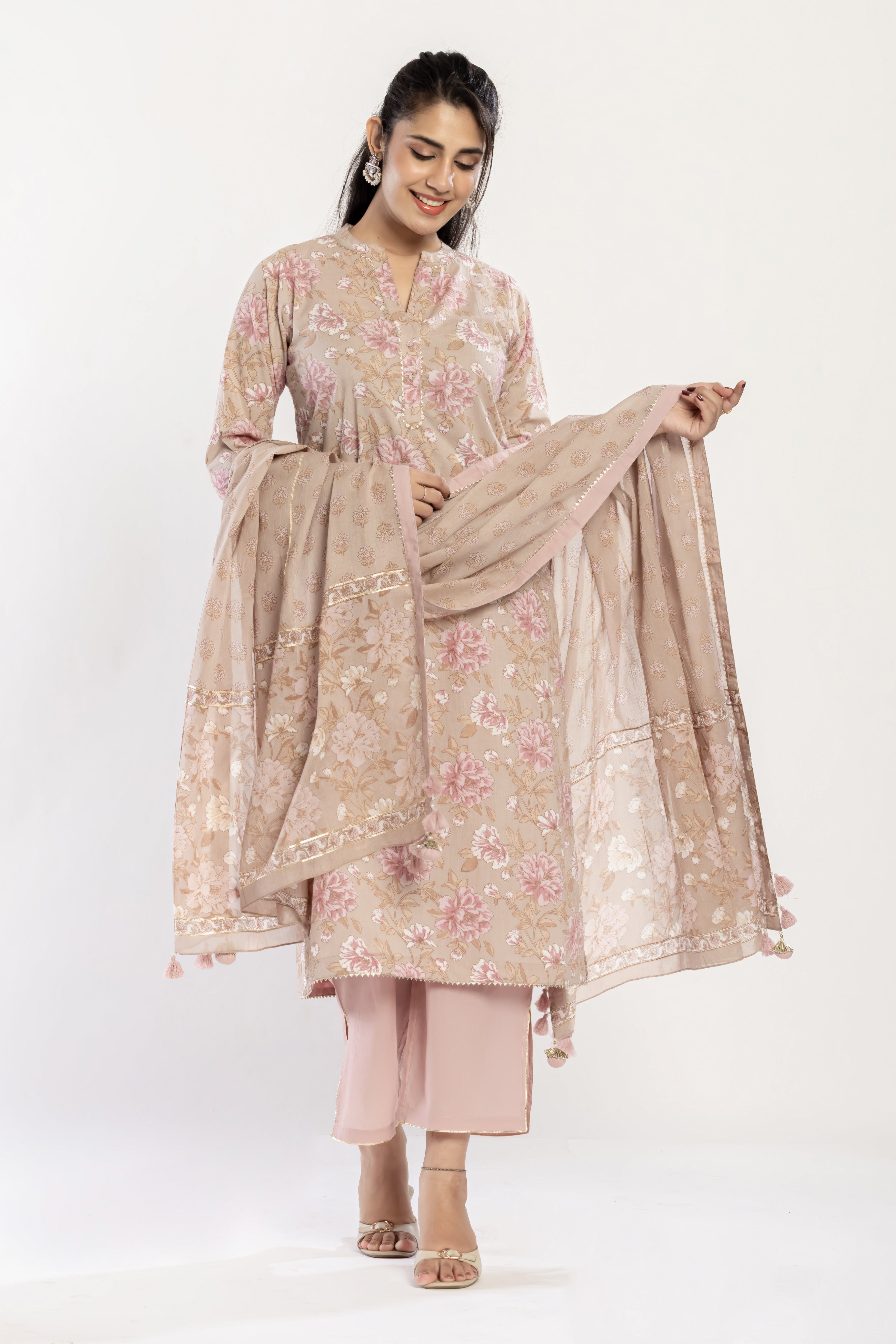 Woman wearing a floral kurta with a matching dupatta on a white background