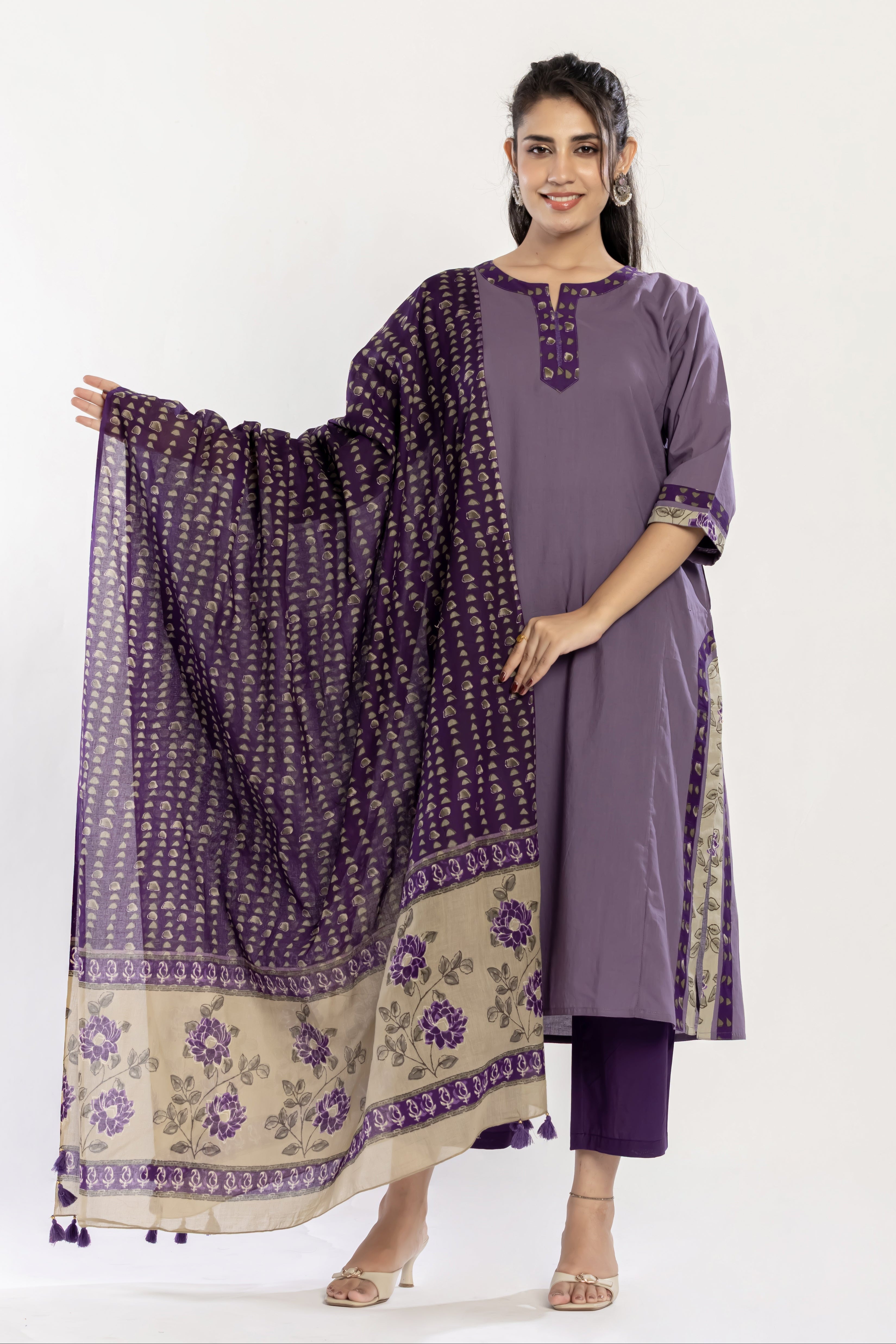 Woman wearing a purple traditional outfit with a matching dupatta on a white background