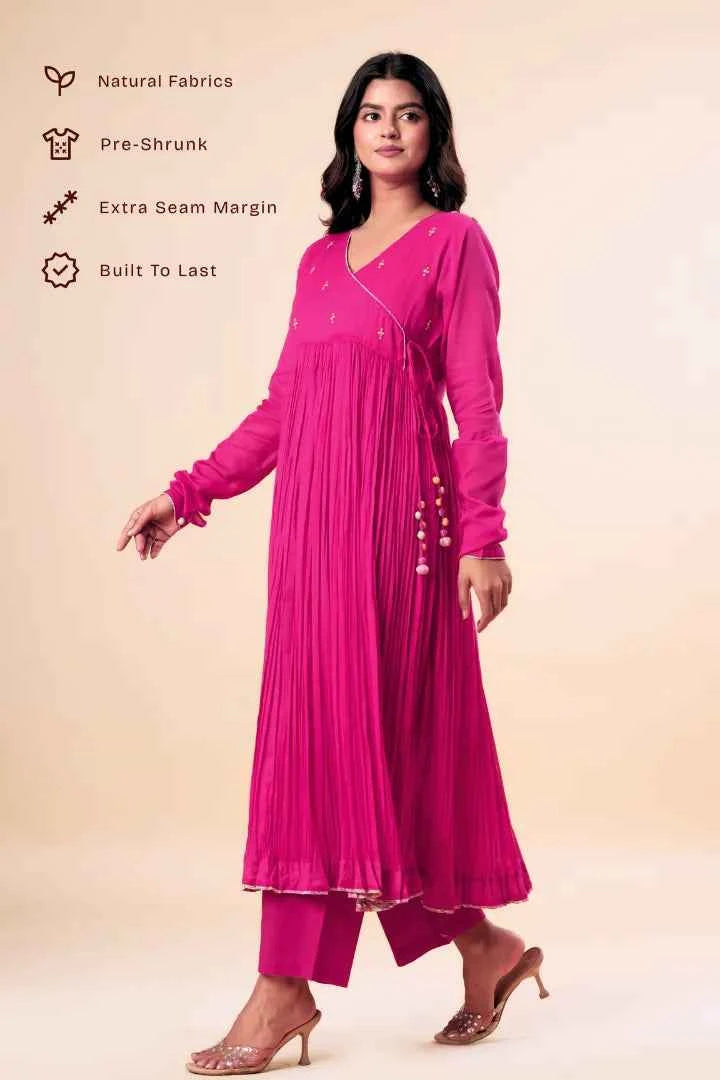 Woman wearing a pink traditional outfit with text on natural fabrics and manufacturing details.