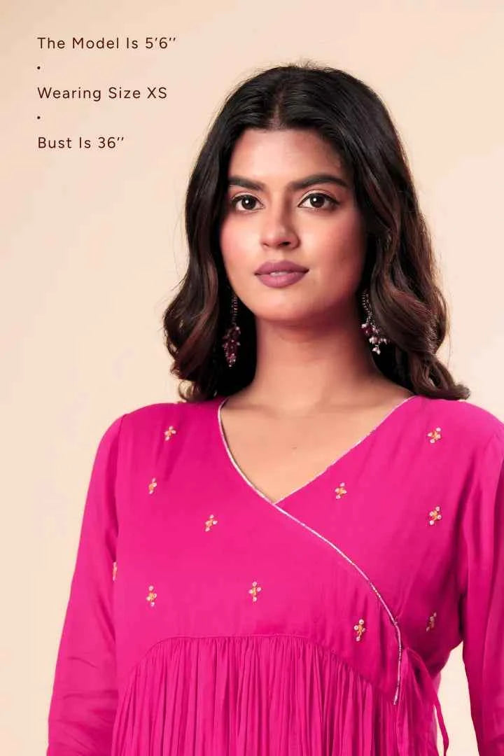 Woman wearing a pink dress with yellow floral patterns on a beige background