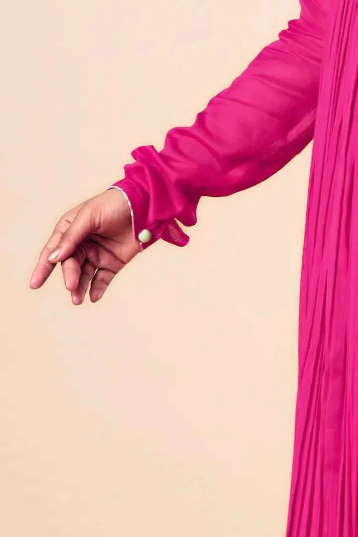 Close-up of a hand wearing a pink sleeve against a beige background