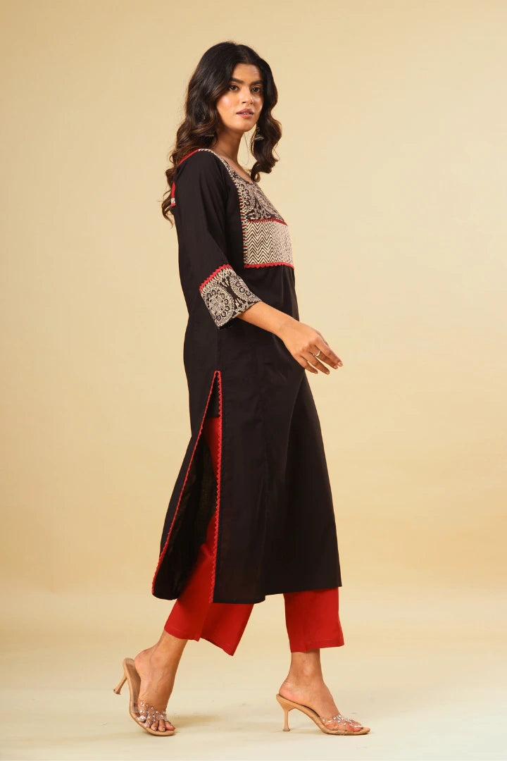 Woman wearing a black and red traditional outfit on a beige background